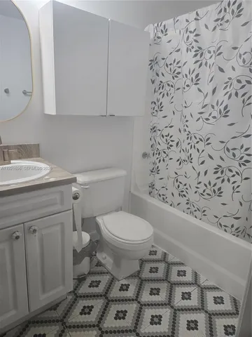 a bathroom with a toilet and a shower curtain