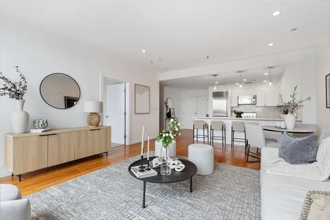 a living room with furniture and a wooden floor