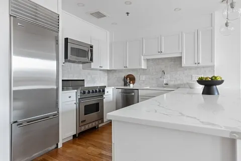 a kitchen with a refrigerator stove and white cabinets