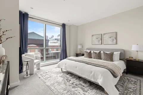 a bedroom with a large bed and a large window