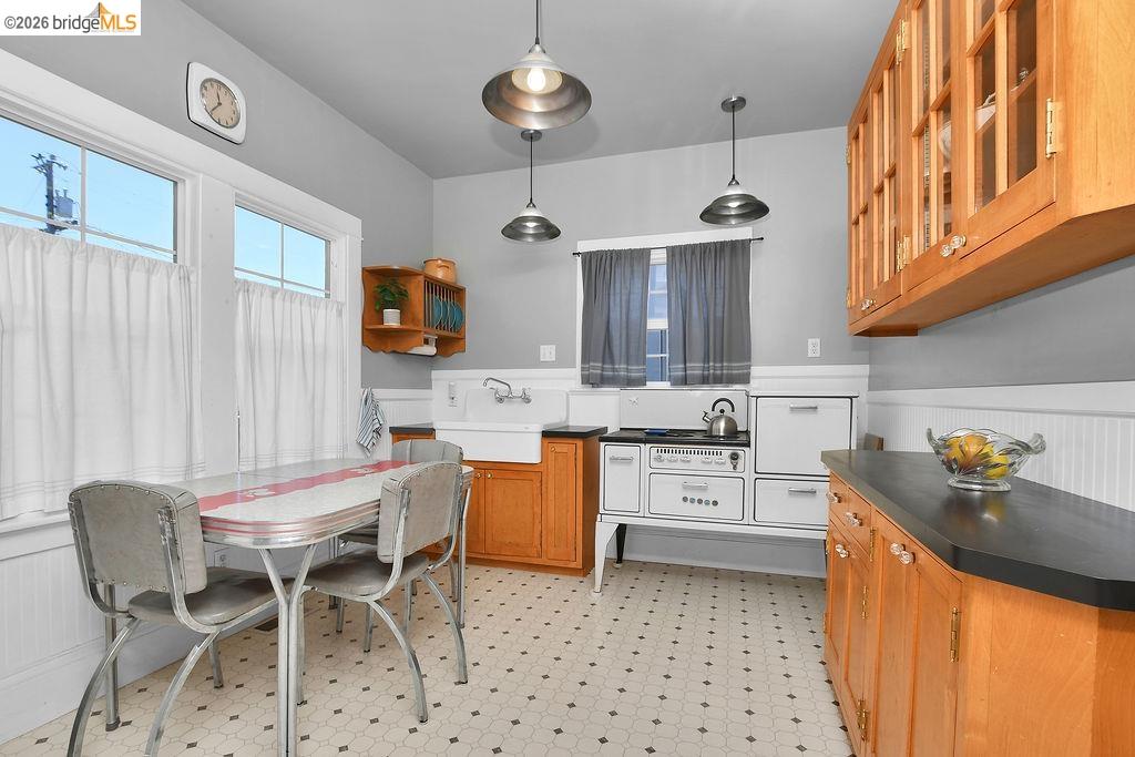 325 South 2nd Street Rio Vista, CA 94571 - Photo 14 of 33 Kitchen featuring hexagonal tile flooring, wood cabinetry, a farmhouse sink, solid surface countertops, and white beadboard paneling