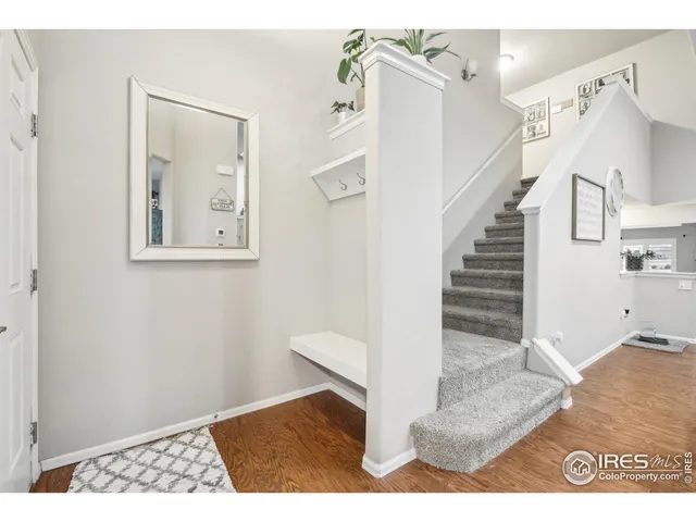 a view of a hallway with wooden floor and staircase