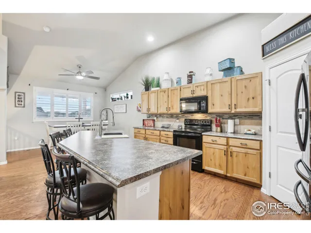 a open kitchen with stainless steel appliances granite countertop a stove refrigerator and a view of living room