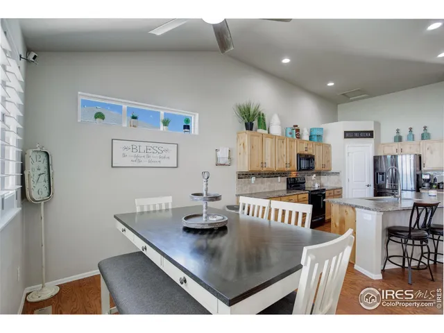 a living room with stainless steel appliances furniture a rug and a kitchen view