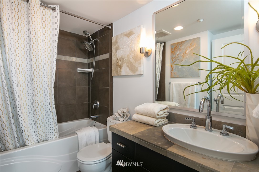 819 Virginia Street, Unit 2804 Seattle, WA 98101 - Photo 9 of 22 a bathroom with a granite countertop sink mirror vanity and toilet