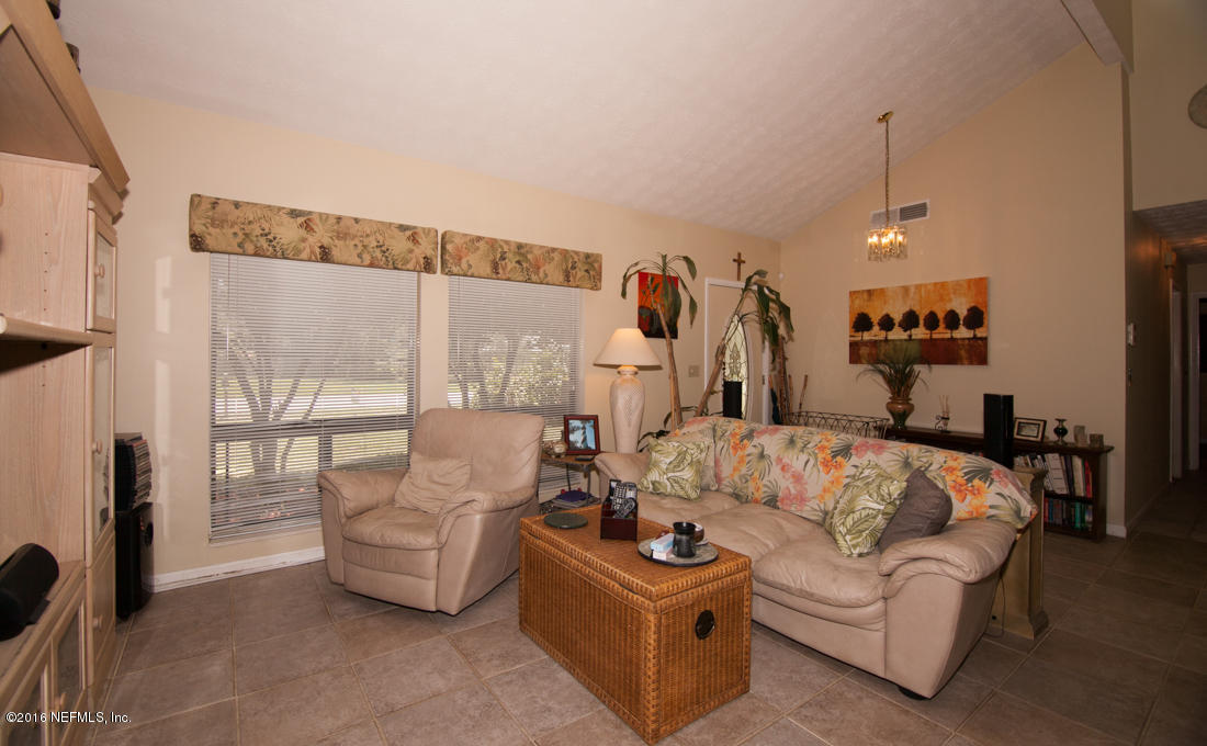 12594 Agatite Road Jacksonville, FL 32258 - Photo 11 of 49 a living room with furniture and a chandelier