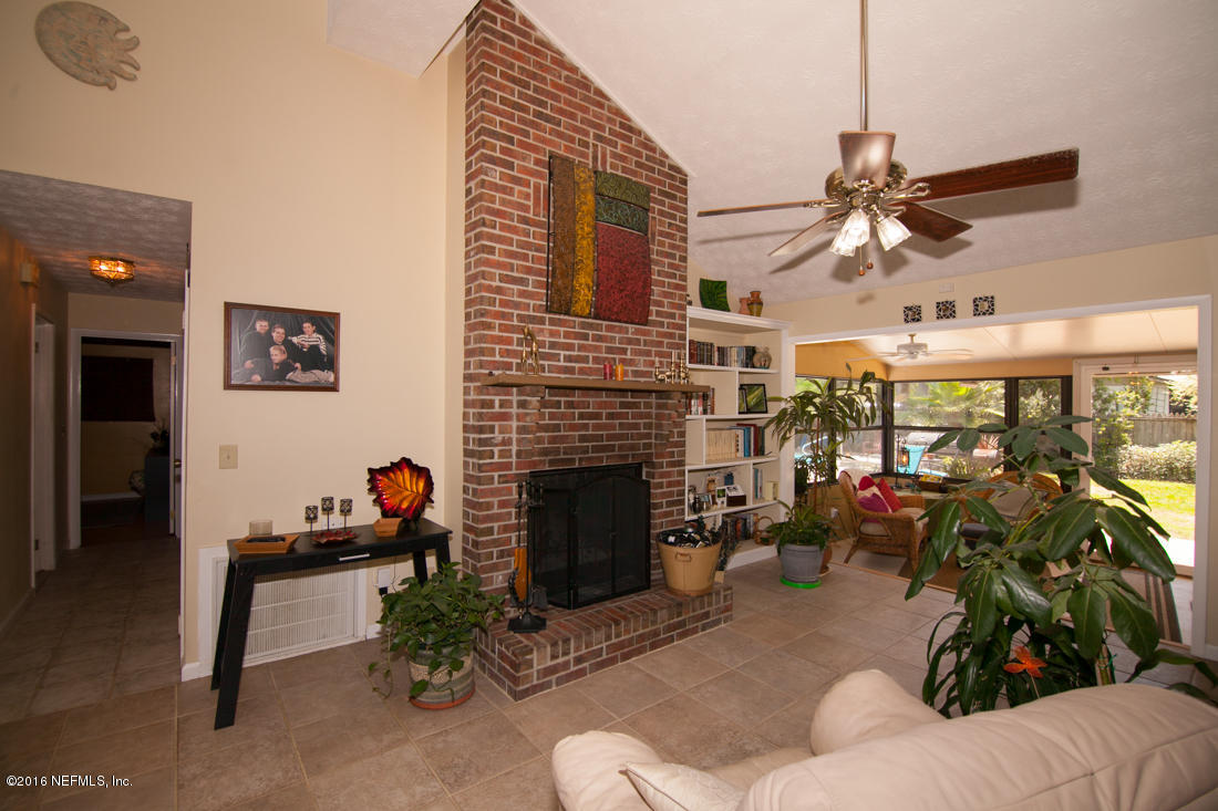 12594 Agatite Road Jacksonville, FL 32258 - Photo 13 of 49 a living room with furniture a fireplace and a chandelier