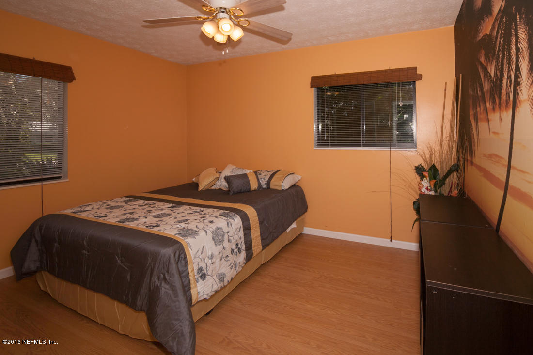 12594 Agatite Road Jacksonville, FL 32258 - Photo 26 of 49 a bedroom with a bed and a chandelier