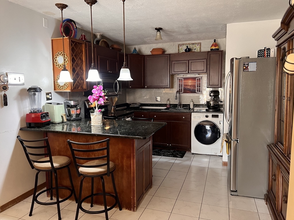 215 Washington Avenue, Unit 9 Chelsea, MA 02150 - Photo 2 of 16 a kitchen with a sink stove and cabinets