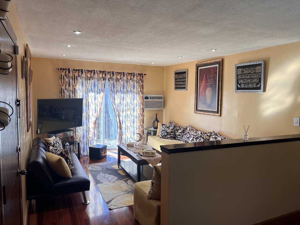 215 Washington Avenue, Unit 9 Chelsea, MA 02150 - Photo 4 of 16 a living room with furniture and a flat screen tv