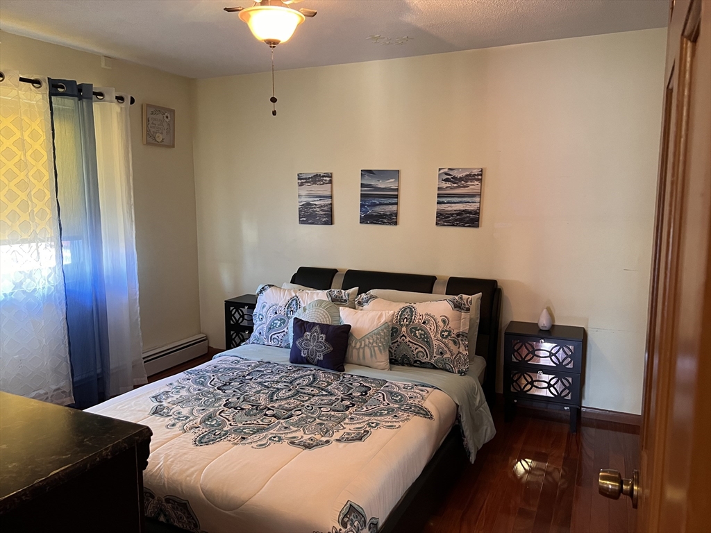 215 Washington Avenue, Unit 9 Chelsea, MA 02150 - Photo 6 of 16 a bedroom with a bed and a chandelier