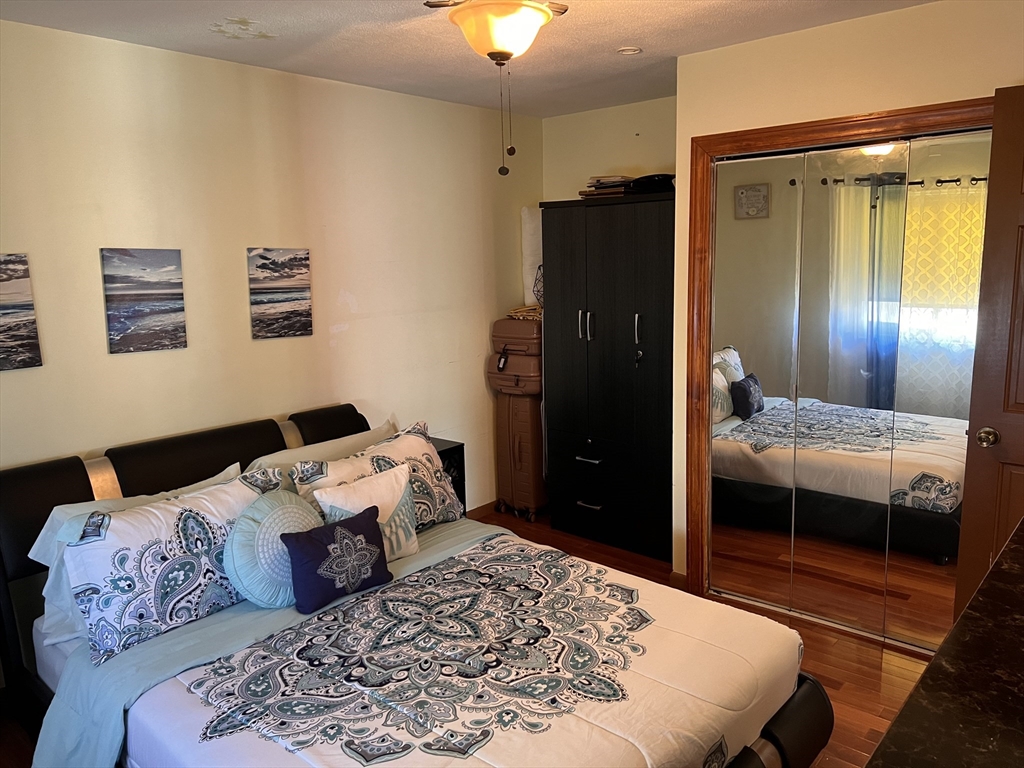 215 Washington Avenue, Unit 9 Chelsea, MA 02150 - Photo 7 of 16 a bedroom with a bed and a dresser