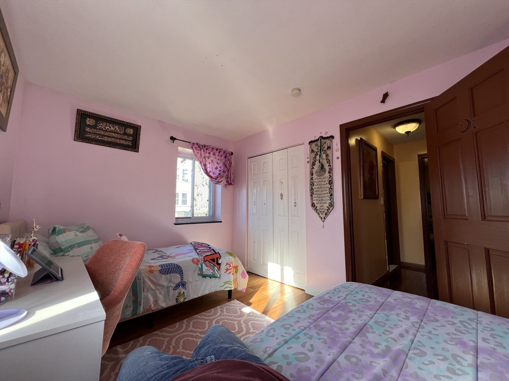 215 Washington Avenue, Unit 9 Chelsea, MA 02150 - Photo 9 of 16 a bedroom with a bed and wooden floor
