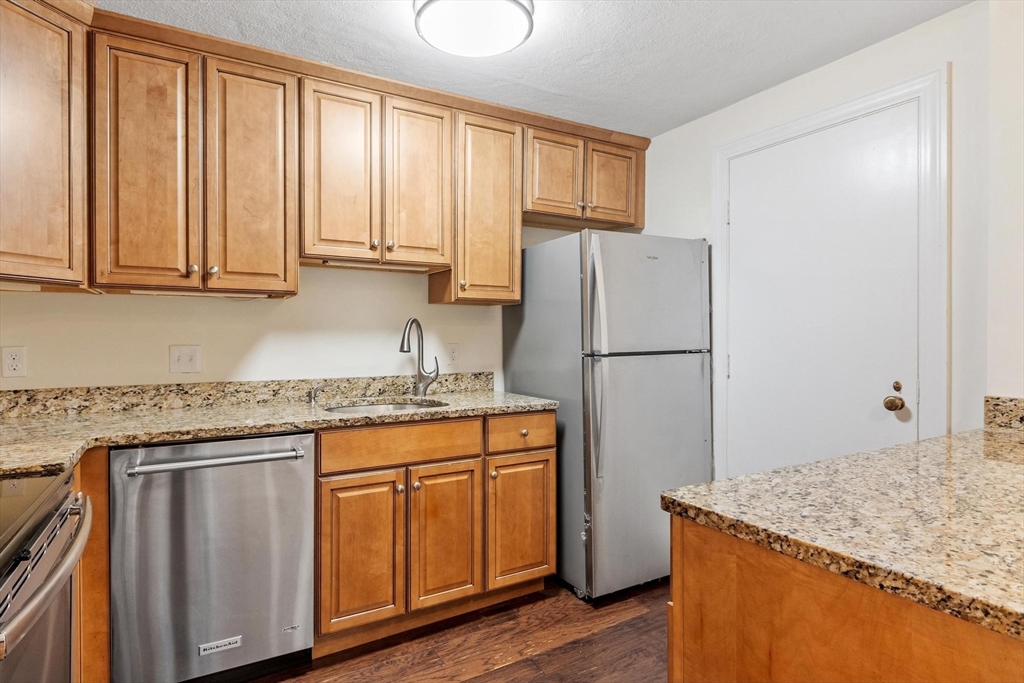 420 Great Road, Unit C1 Acton, MA 01720 - Photo 4 of 29 a kitchen with stainless steel appliances granite countertop a refrigerator sink and cabinets