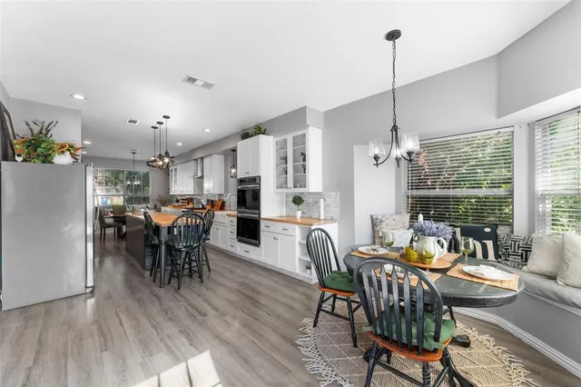 a dining room with furniture a chandelier and wooden floor