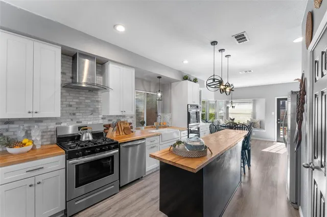 a kitchen with a counter top space a sink stainless steel appliances and cabinets