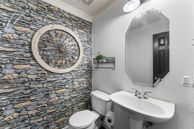 a bathroom with a toilet sink mirror and vanity
