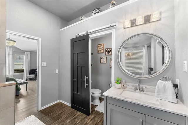 a en suite bathroom with a granite countertop toilet sink and mirror