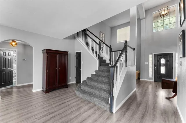 a view of a hallway with wooden floor and staircase