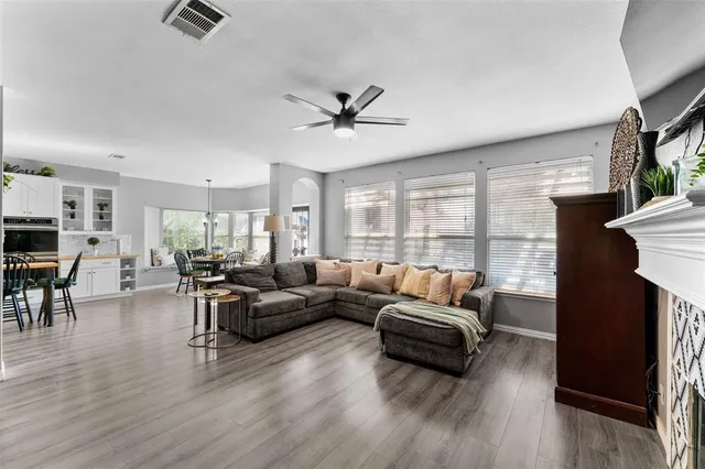 a living room with furniture ceiling fan and a large window