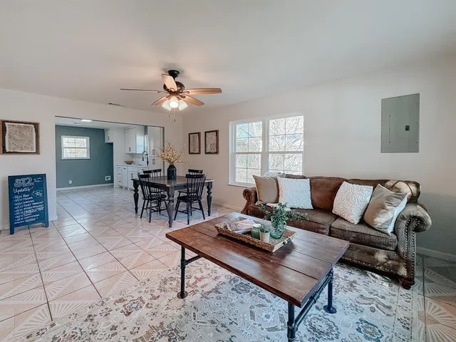 a living room with furniture a chandelier and a rug