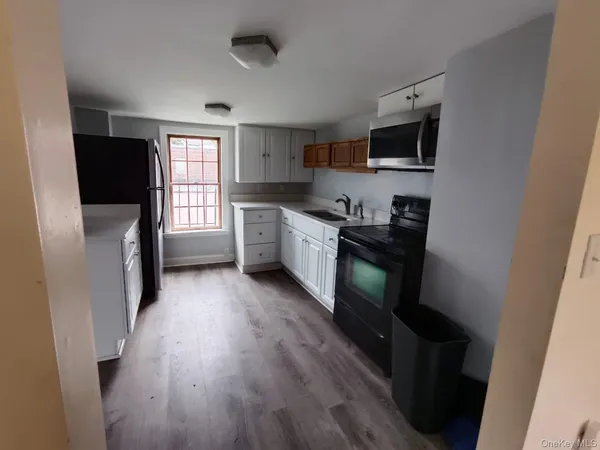 a kitchen with granite countertop a refrigerator stove and sink