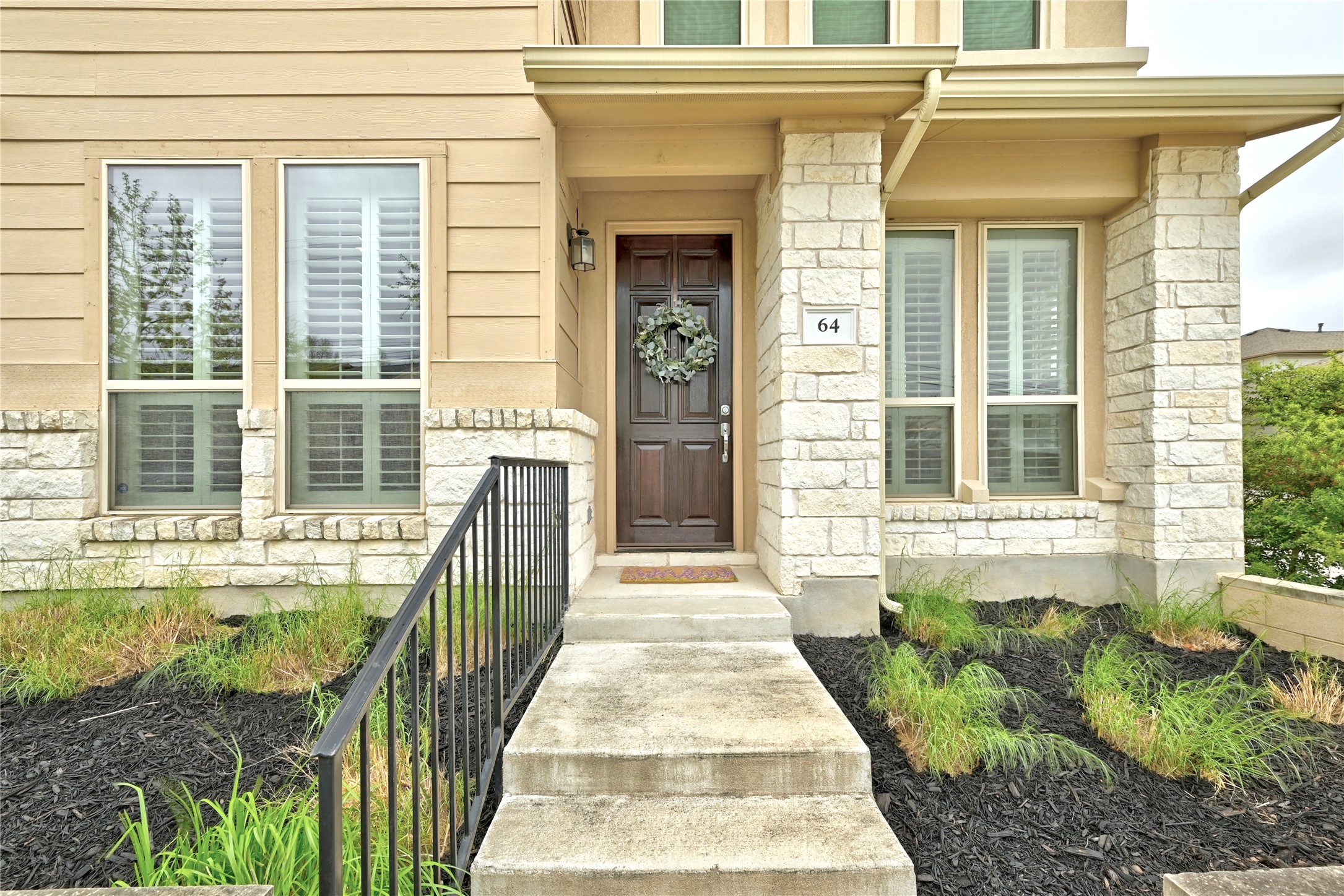 6814 East Riverside Drive, Unit 64 Austin, TX 78741 - Photo 2 of 17 A welcoming front entrance featuring natural stone accents and classic wood siding.