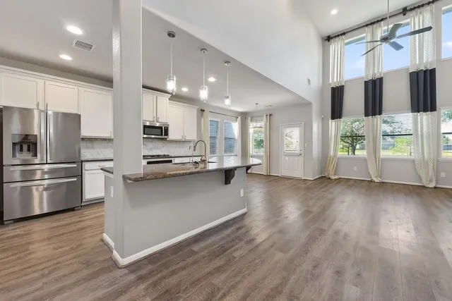 a kitchen with stainless steel appliances a refrigerator and a stove top oven