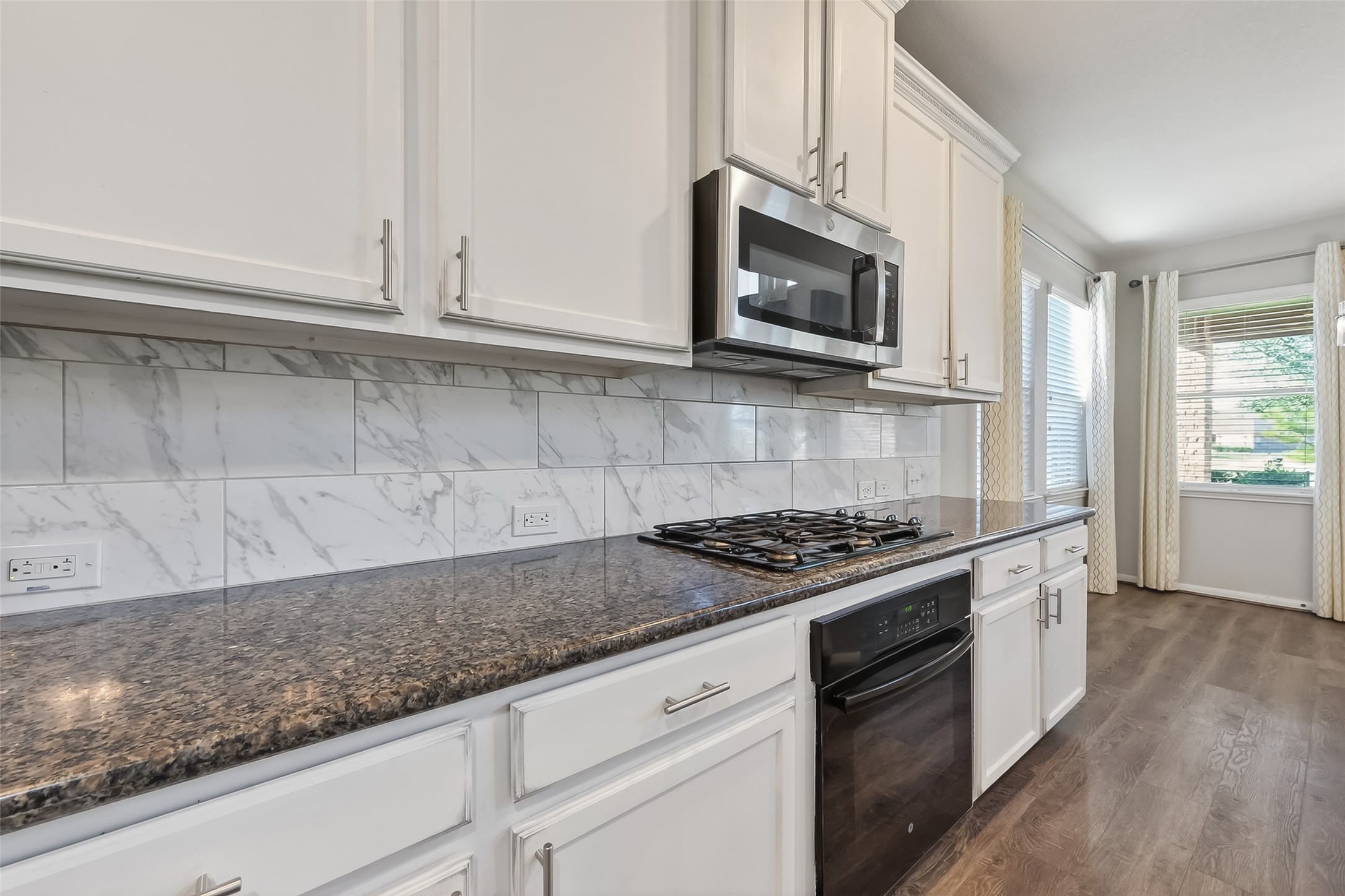 9151 Monarch Field Lane Cypress, TX 77433 - Photo 19 of 48 a kitchen with granite countertop white cabinets and stainless steel appliances