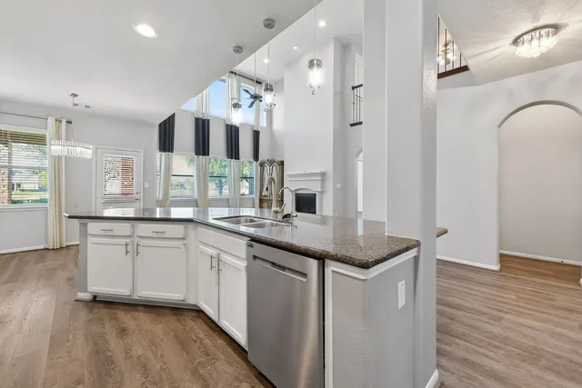 a spacious bathroom with a granite countertop sink a mirror and shower