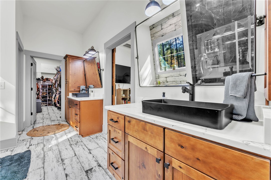 919 Watercrest Road West Union, SC 29696 - Photo 19 of 50 This bathroom features dual vanities and rustic wood flooring, offering a perfect blend of style and function.