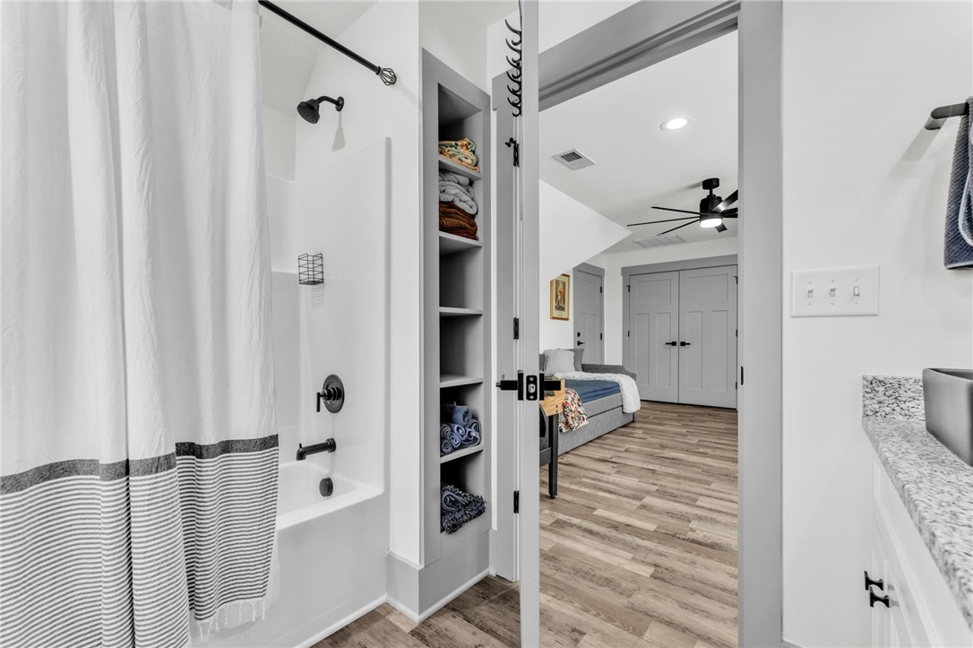 919 Watercrest Road West Union, SC 29696 - Photo 24 of 50 This functional bathroom features a shower-tub combo and convenient built-in shelving, connecting to a versatile living space.