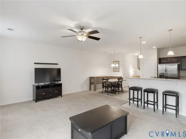 a living room with furniture and a dining table with kitchen view