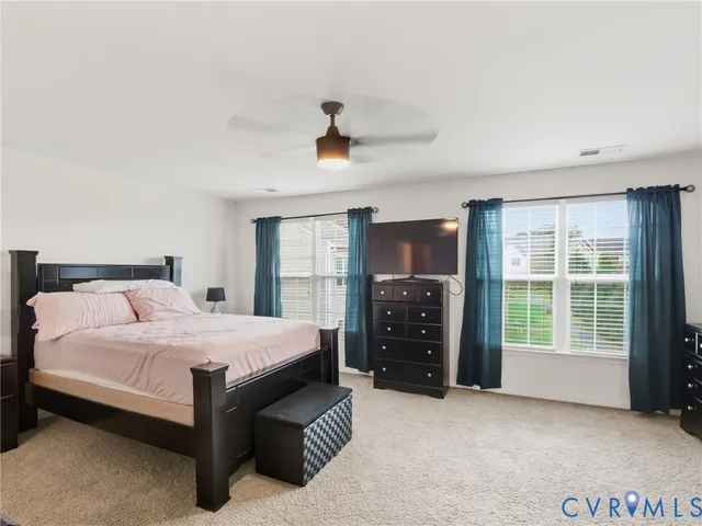 a bedroom with a bed and a flat tv screen on dresser