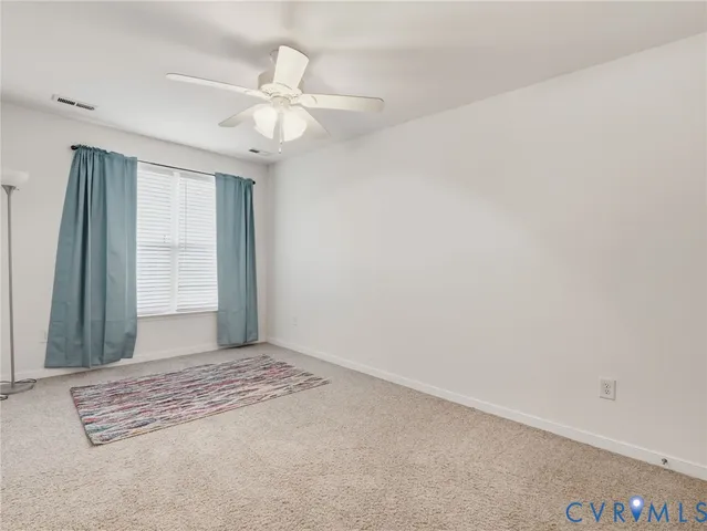 a view of a livingroom with a ceiling fan and window