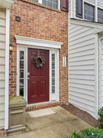 a view of a brick house with a door and a large window