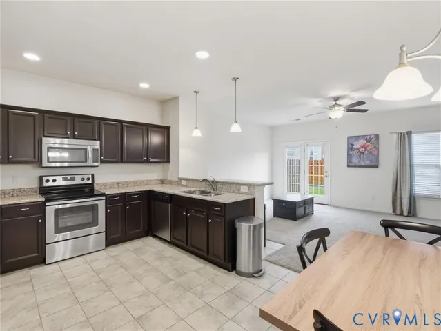 a kitchen with a dining table chairs sink and granite counter tops