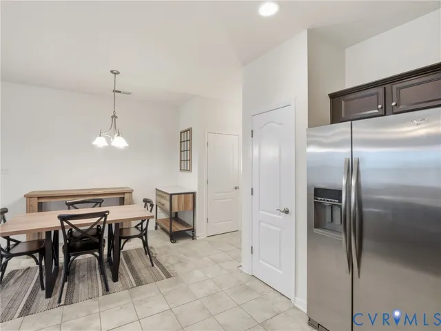 a kitchen with stainless steel appliances kitchen island a table chairs in it and wooden floors