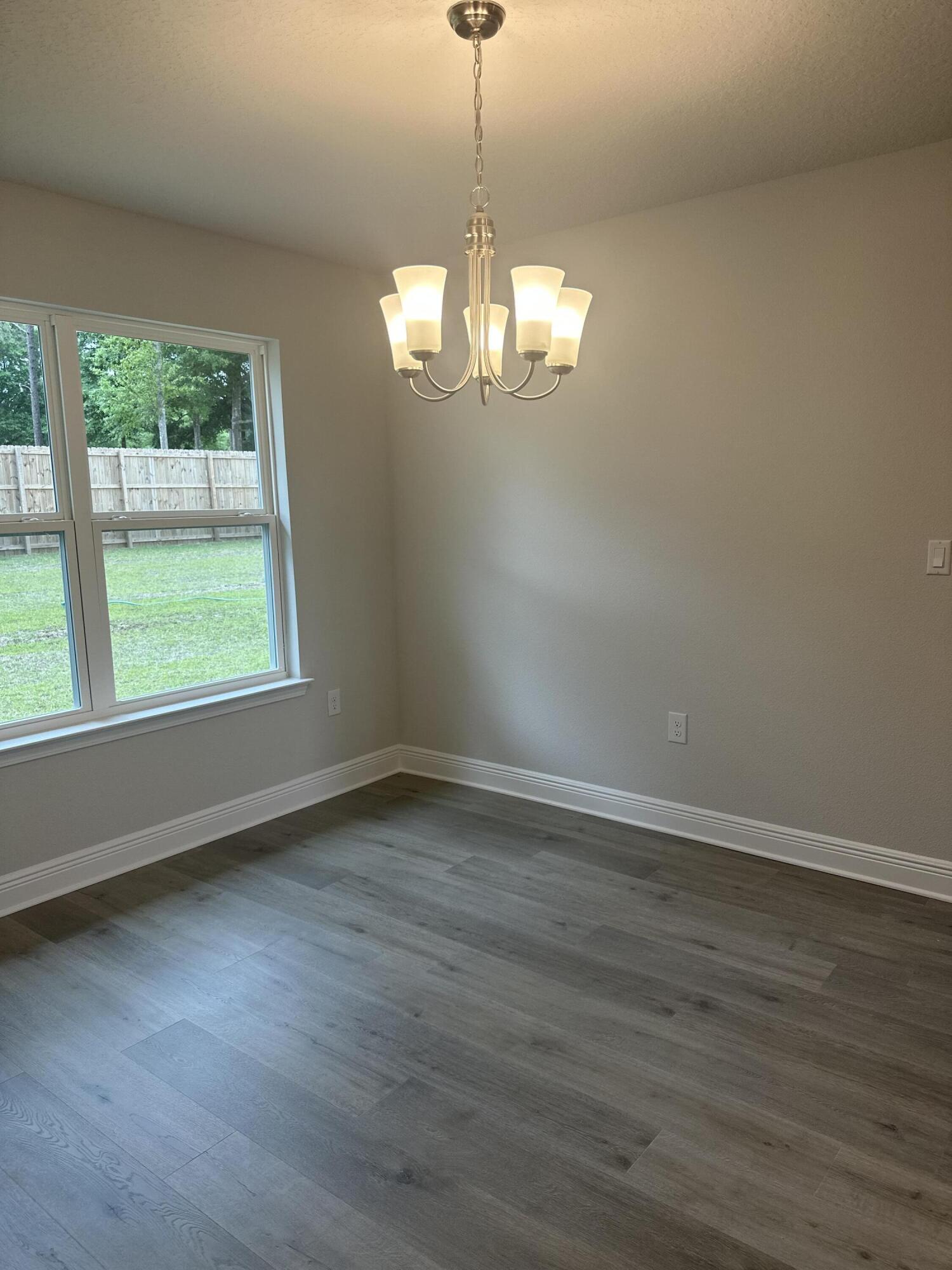 6115 Buckshot Drive Crestview, FL 32539 - Photo 14 of 29 a view of a room with wooden floor chandelier and windows