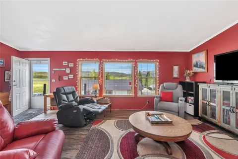 a living room with furniture a flat screen tv and a large window