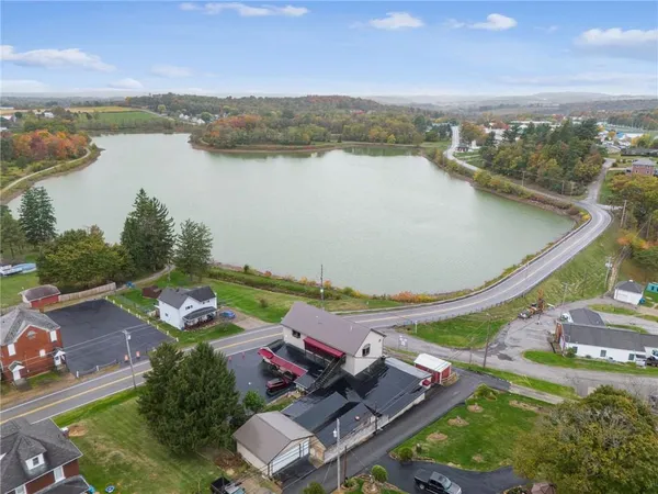 an aerial view of a house with pool lake view and mountain view
