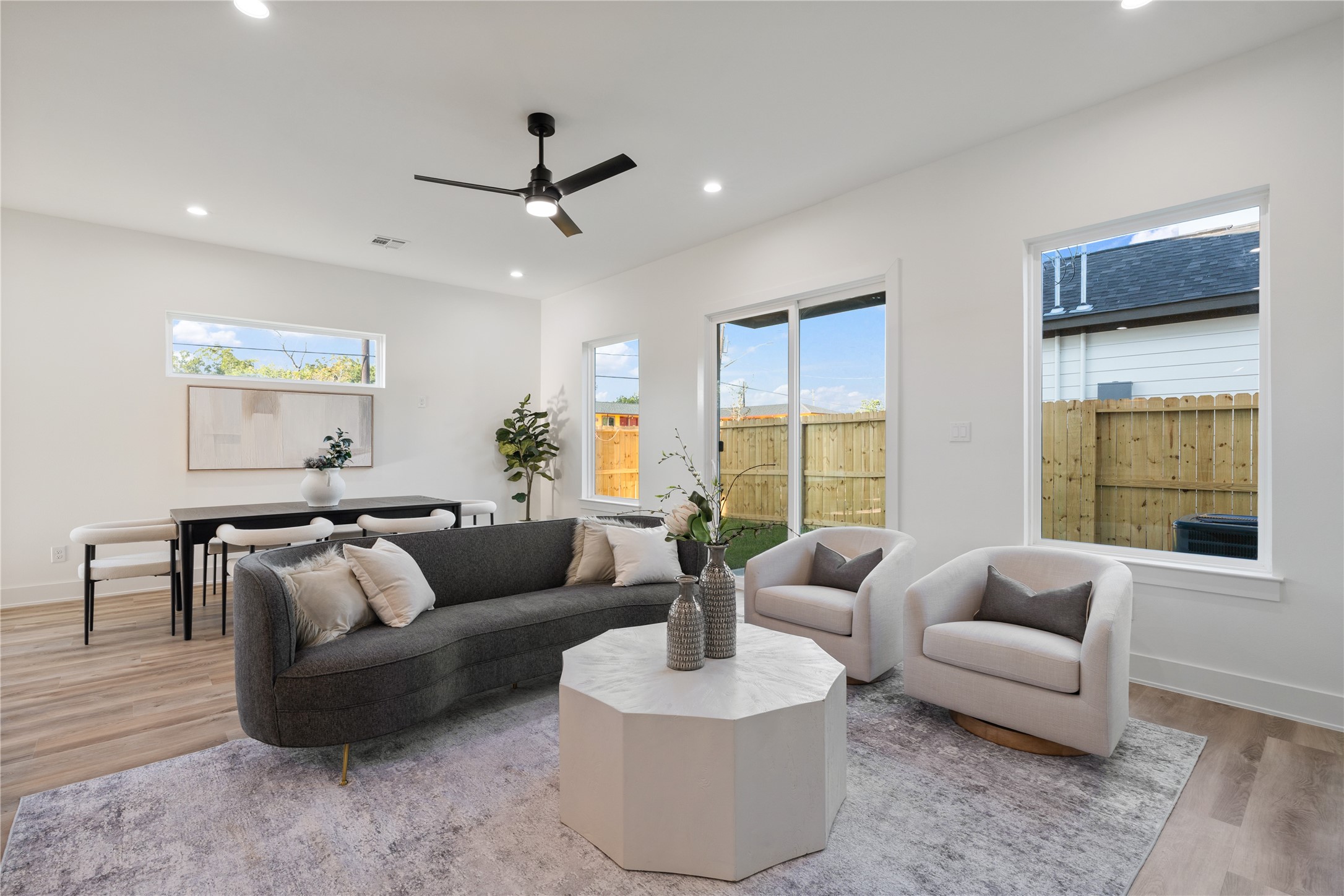 9003 Comal Street Houston, TX 77051 - Photo 12 of 36 This picture-perfect living area is highlighted by expansive windows and sliding doors, flooding the space with natural light. The bright, airy atmosphere enhances the open layout, creating a welcoming and cozy environment. It’s an ideal space for both everyday living and entertaining