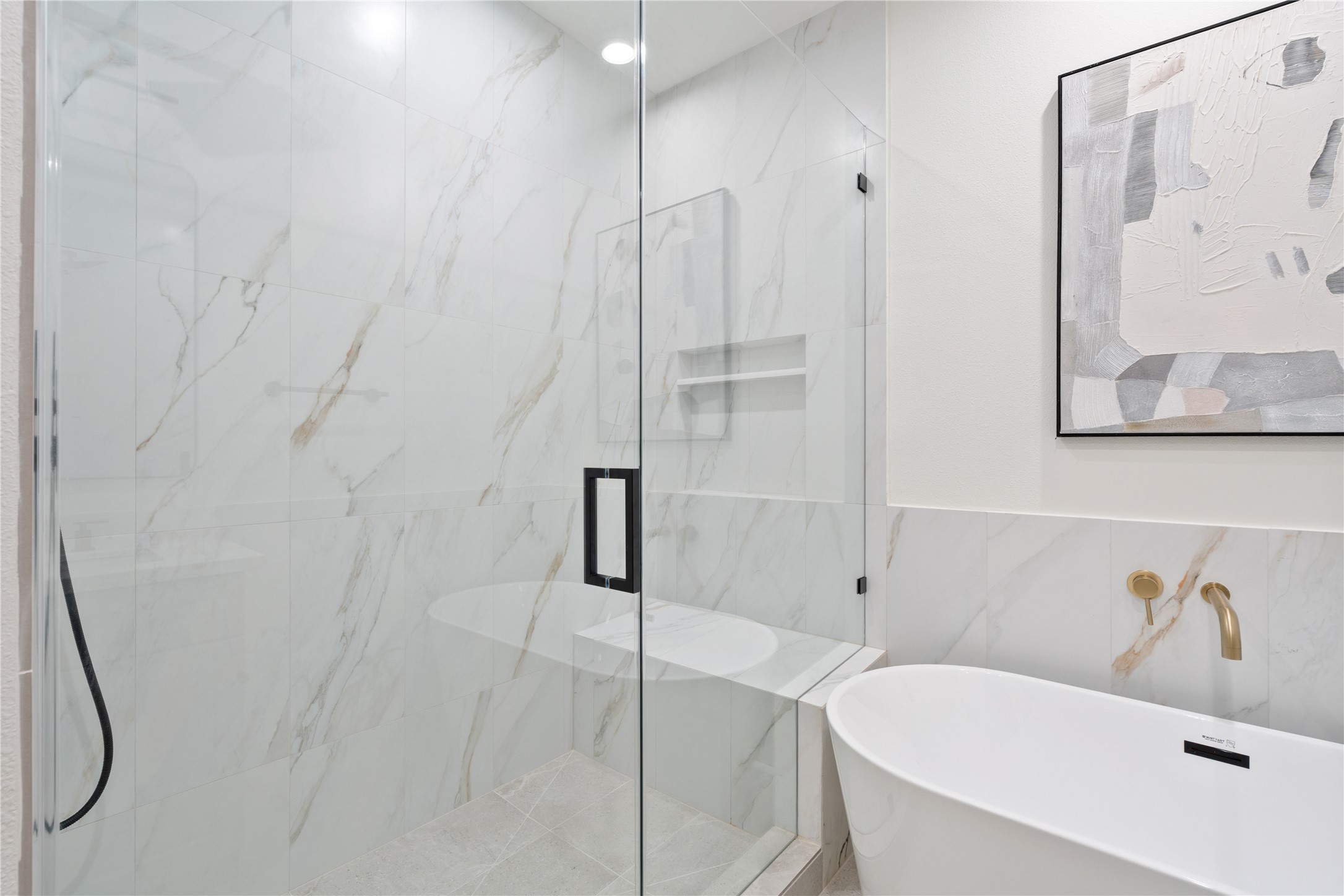9003 Comal Street Houston, TX 77051 - Photo 27 of 36 The primary ensuite features a huge frameless walk-in shower. Its spacious design offers comfort and ease of use while maintaining a clean, open feel. This luxurious feature enhances the spa-like atmosphere of the bathroom
