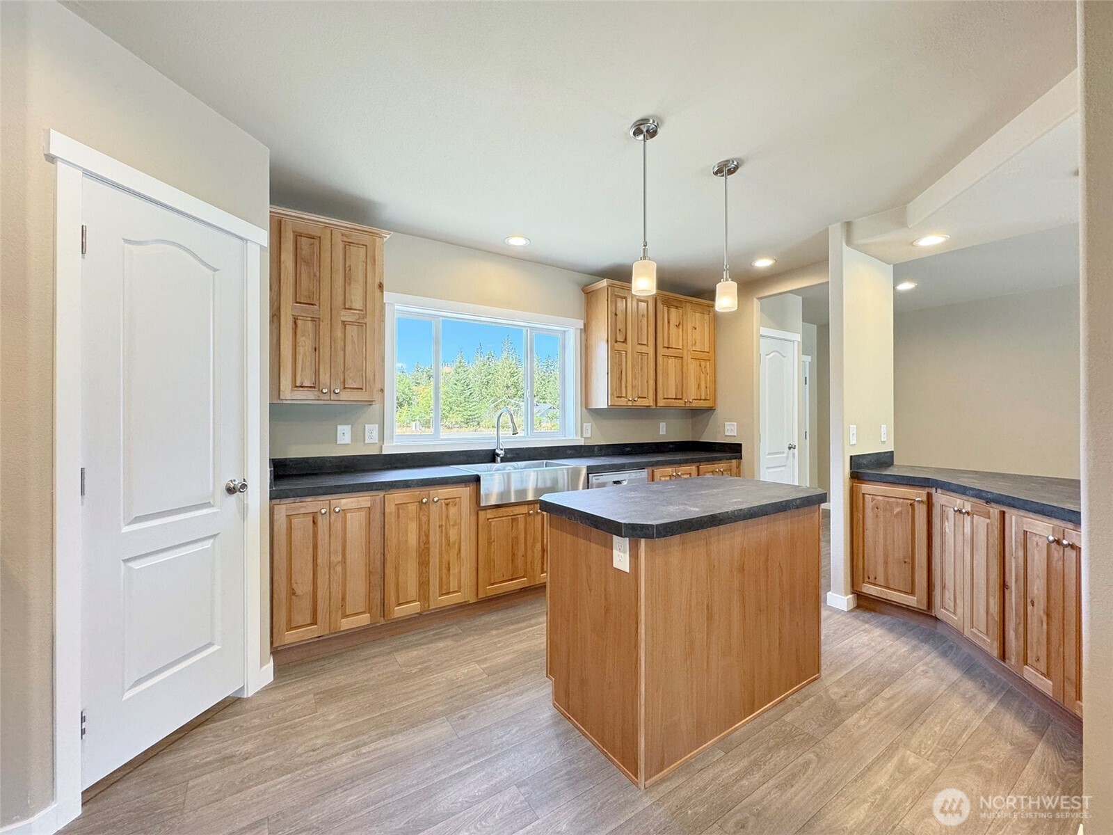 41 Butterfly Lane Pacific Beach, WA 98571 - Photo 11 of 37 a kitchen with stainless steel appliances granite countertop a stove a sink a refrigerator and white cabinets with wooden floor