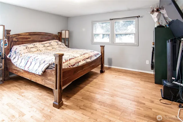 a bedroom with a bed window and a flat tv screen
