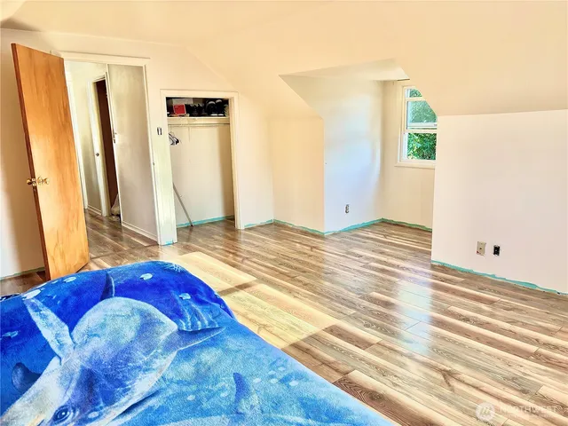 a bedroom with a bed and wooden floor