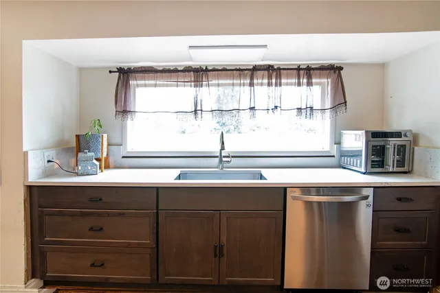 a sink with a window and cabinets
