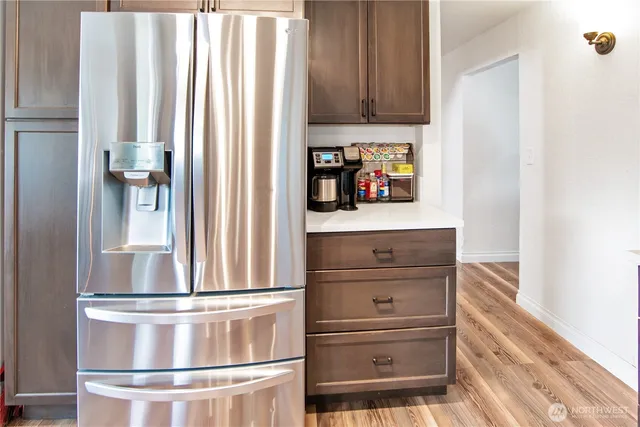 a view of kitchen with wooden floor and cabinets