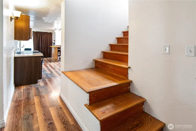 a view of a hallway with wooden floor and staircase