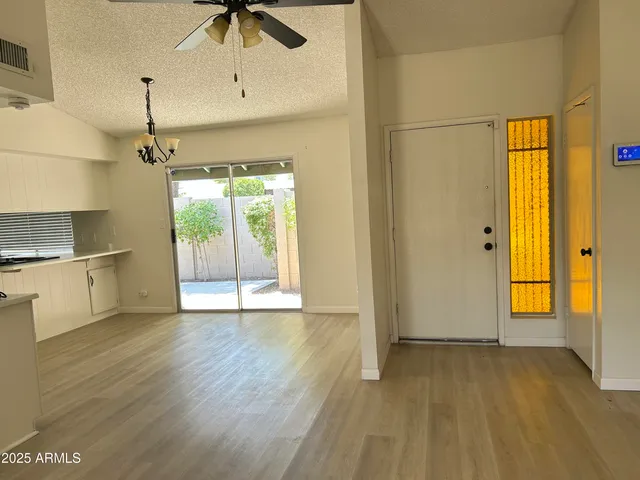a view of an empty room with window and wooden floor